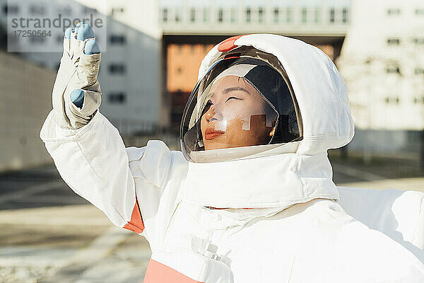 Junge Astronautin im Raumanzug  die ihre Augen vor Sonnenlicht schützt