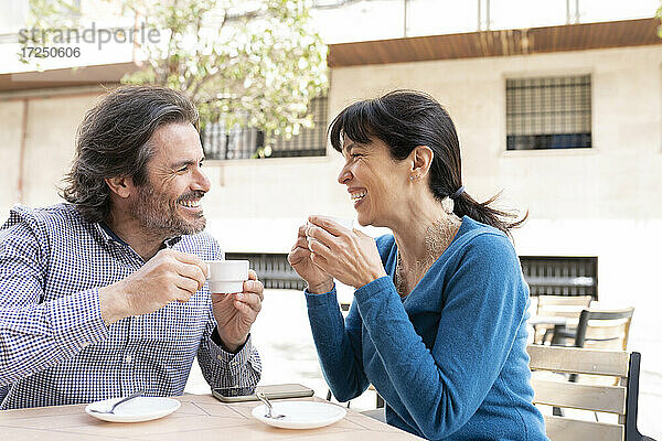 Glückliches reifes Paar lächelnd bei einem Kaffee auf der Terrasse