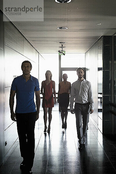 Männliche und weibliche Unternehmer gehen im Korridor eines Büros spazieren