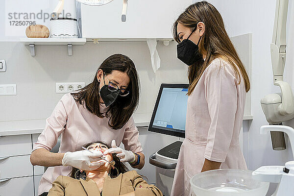 Zahnärztinnen untersuchen die Zähne von Patienten in der Klinik