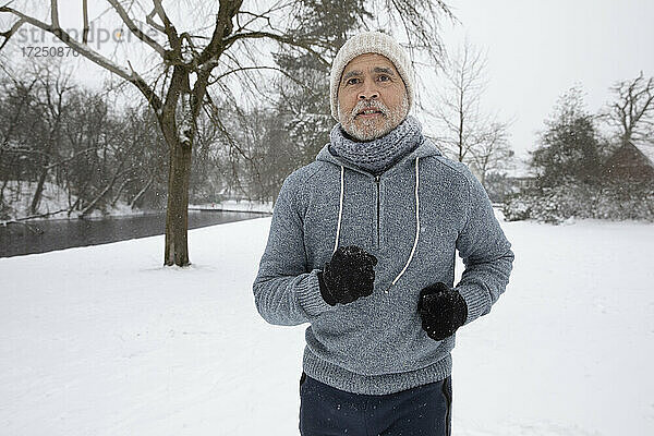 Älterer Mann in warmer Kleidung beim Laufen im Park