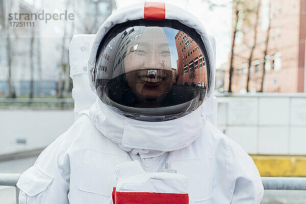 Lächelnde Astronautin im Raumanzug in der Stadt