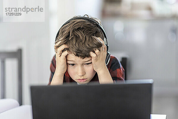 Müder Junge besucht Fernunterricht über Laptop zu Hause