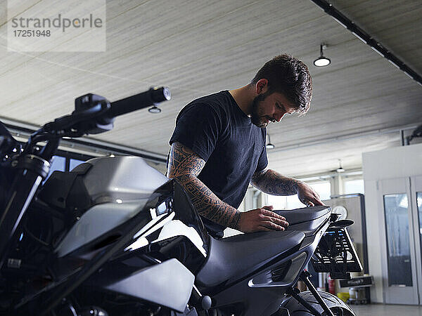 Mechaniker beim Einbau eines Motorradsitzes in der Werkstatt