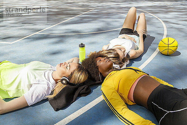 Freunde entspannen sich auf dem Boden des Sportplatzes