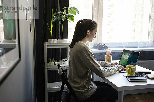 Frau benutzt Laptop bei der Arbeit zu Hause