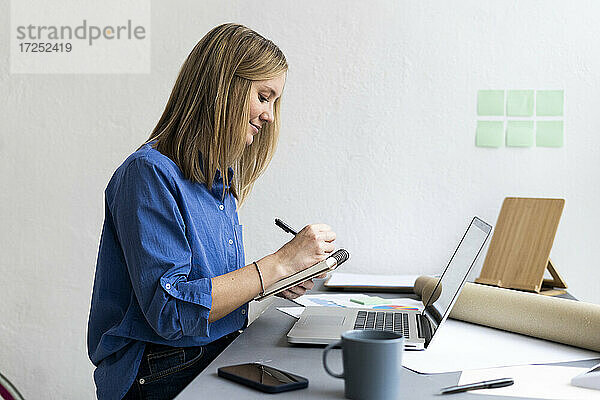 Geschäftsfrau beim Schreiben mit Laptop im Büro