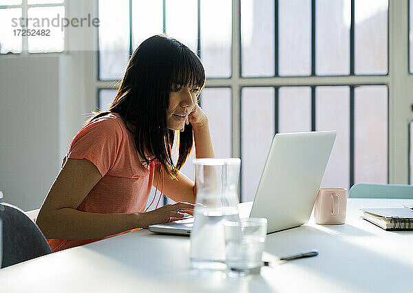 Geschäftsfrau mit Laptop auf dem Tisch bei der Arbeit im Heimbüro