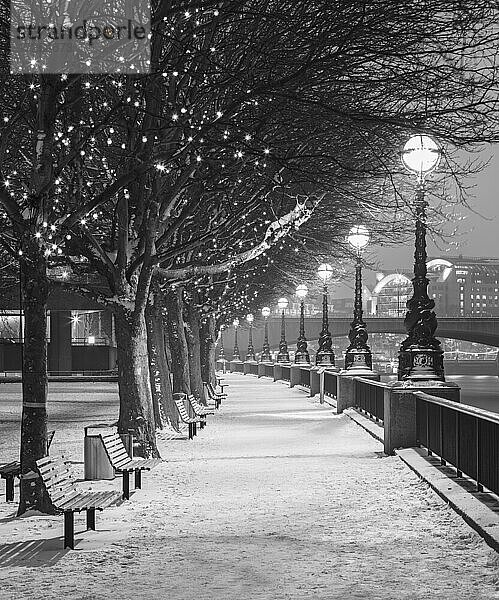 UK  England  London  Reihe von Straßenlaternen  die eine leere  schneebedeckte Promenade beleuchten
