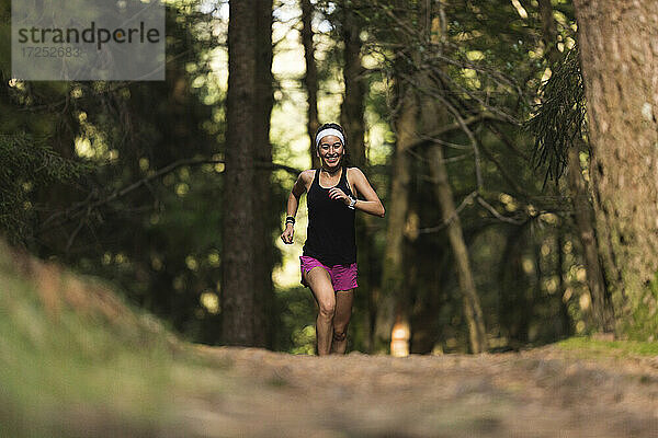 Junge Sportlerin beim Laufen im Wald