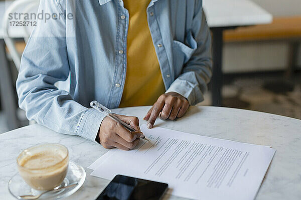 Weibliche Fachkraft bei der Vertragsunterzeichnung im Café