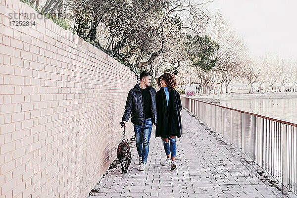 Junges Paar mit Hund auf dem Fußweg