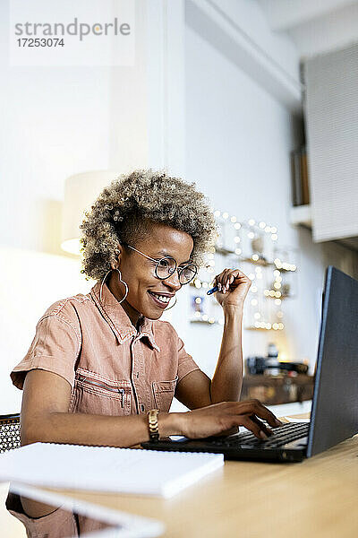 Geschäftsfrau mit Brille bei der Arbeit am Laptop im Home Office