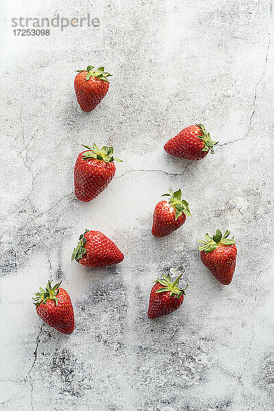 Frische Erdbeeren liegen auf weißem Marmor