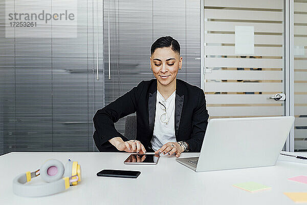 Junge Geschäftsfrau  die ein digitales Tablet bei der Arbeit im Büro benutzt