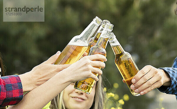 Freunde stoßen mit Bierflaschen an