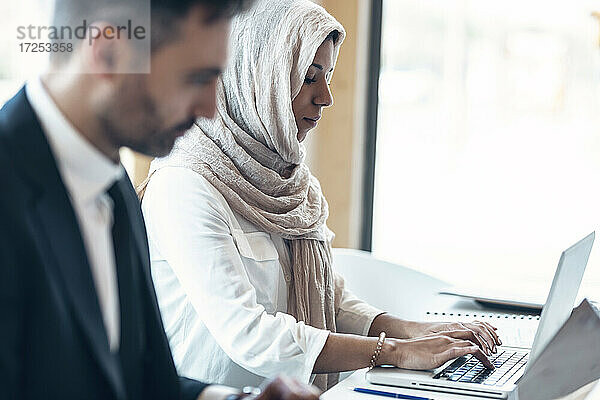 Geschäftsfrau mit männlichem Fachmann  der einen Laptop im Büro benutzt