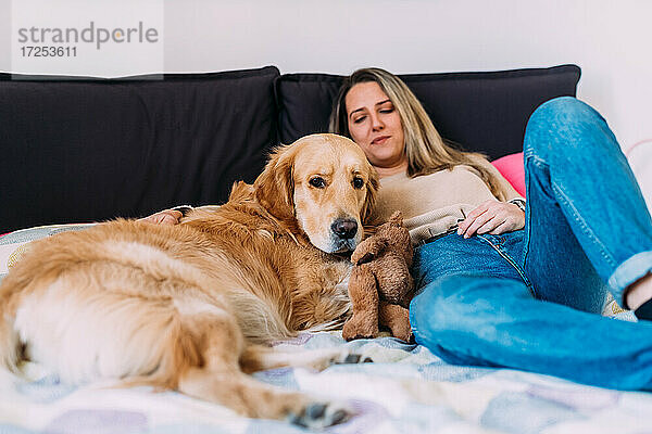 Italien  Junge Frau mit Hund entspannt auf dem Bett