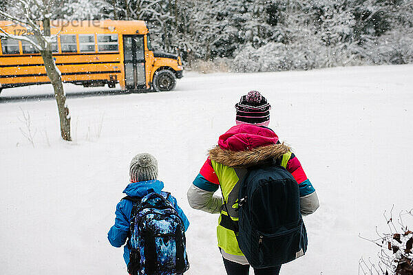 Kanada  Ontario  Rückansicht von Kindern auf dem Weg zum Schulbus im Schnee