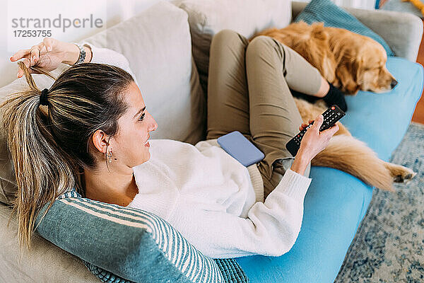 Italien  Junge Frau und Hund entspannen sich auf dem Sofa