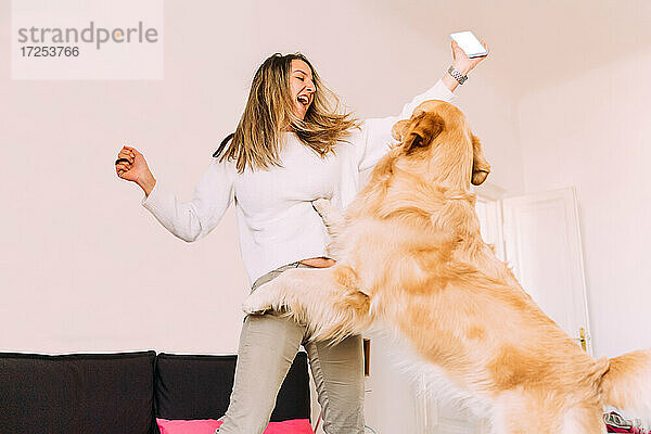 Italien  Junge Frau spielt mit Hund zu Hause