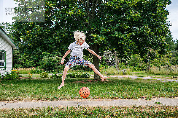 Kanada  Ontario  Junge springt über Basketball im Freien