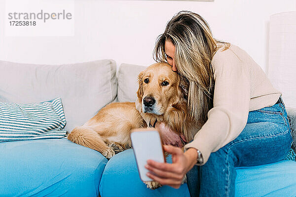 Italien  Junge Frau macht Selfie mit Hund zu Hause