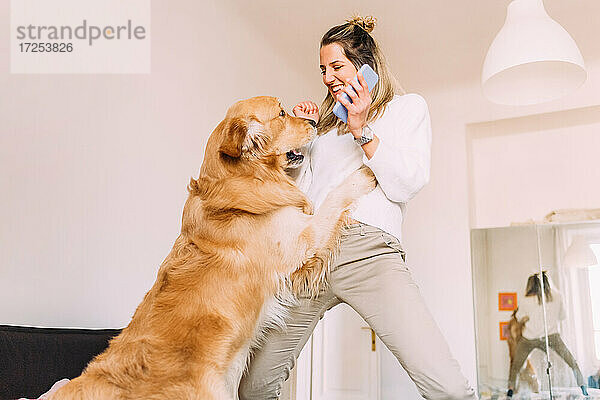 Italien  Junge Frau spielt mit Hund zu Hause