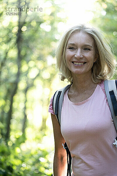 Porträt einer lächelnden reifen Frau im Wald stehend