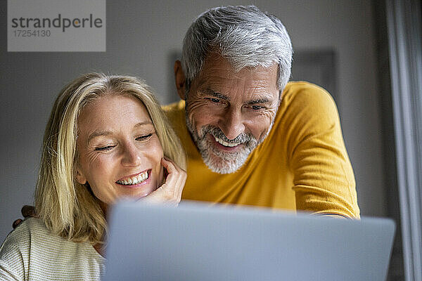Lächelndes reifes Paar mit Laptop