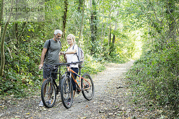 Älteres Paar  das im Wald mit einer Smartwatch die Richtung überprüft