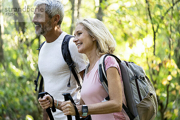 Lächelndes reifes Paar wandert zusammen im Wald