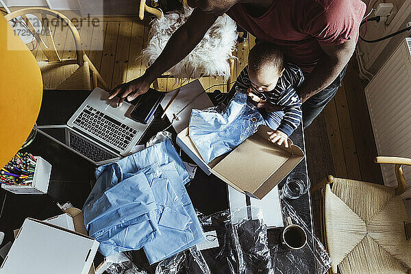 Direkt über der Aufnahme eines männlichen Berufstätigen  der einen Laptop von seinem Sohn zu Hause benutzt