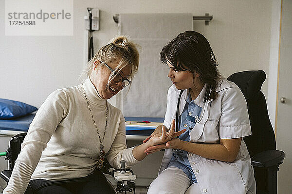 Weiblicher medizinischer Experte prüft den Puls eines behinderten Patienten in einer medizinischen Klinik