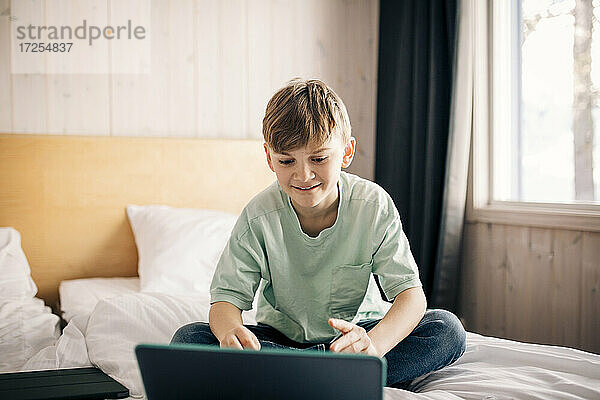 Blonder Junge E-learning durch Laptop zu Hause