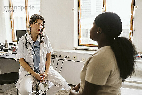 Weiblicher Arzt im Gespräch mit dem Patienten während der Beratung in der medizinischen Klinik