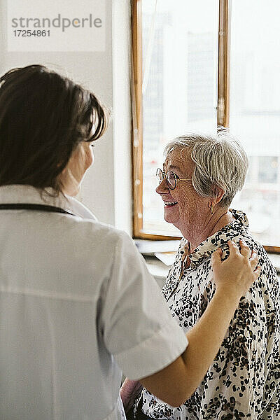 Weibliche Gesundheitspflegerin tröstet älteren Patienten in einer medizinischen Klinik