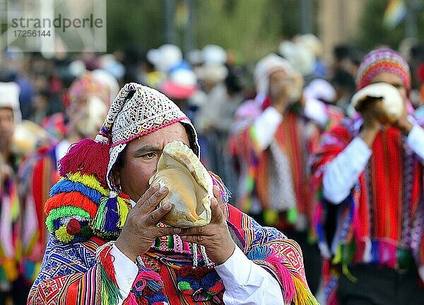 Indigener Mann bläst das Muschelhorn beim Umzug am Vortag von Inti Raymi  Fest der Sonne