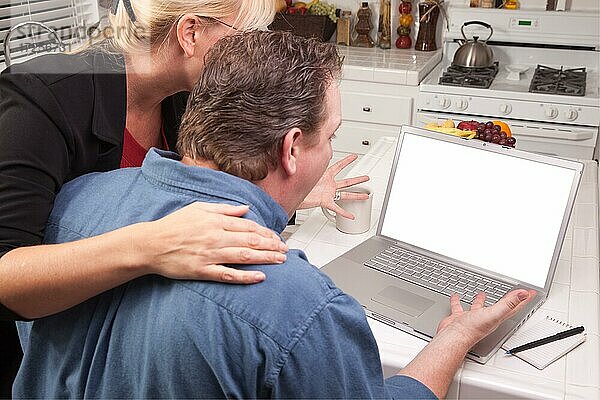 Ehepaar in der Küche mit Laptop mit leerem Bildschirm