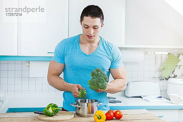 Junger Mann kochen Essen zubereiten Gemüse Mittagessen in der Küche gesunde Ernährung gesund in Deutschland