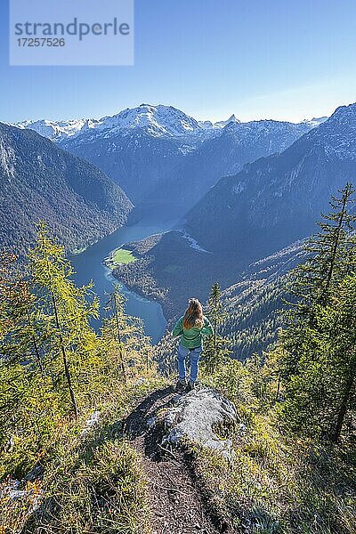 Panoramablick auf den Königssee  Junge Wanderin auf der Achenkanzel  herbstlicher Wald und schneebedeckte Berge  Nationalpark Berchtesgaden  Berchtesgadener Land  Oberbayern  Bayern  Deutschland  Europa