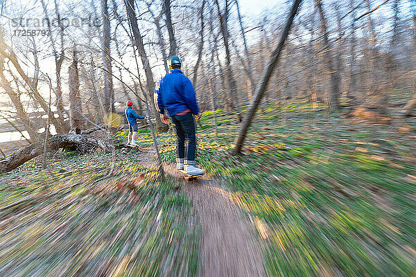 Brüder fahren mit ihren One-Wheels auf einem einspurigen Mountainbike-Trail neben dem Potomac River  Bethesda  Maryland  Vereinigte Staaten von Amerika  Nordamerika