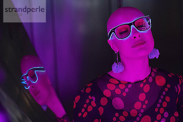 Porträt stilvolle heitere Frau in Neon-Brille