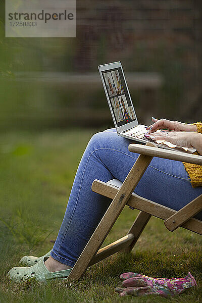 Frau mit Laptop im Garten Rasen Stuhl