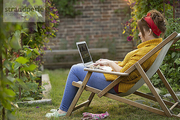 Frau arbeitet am Laptop im Garten