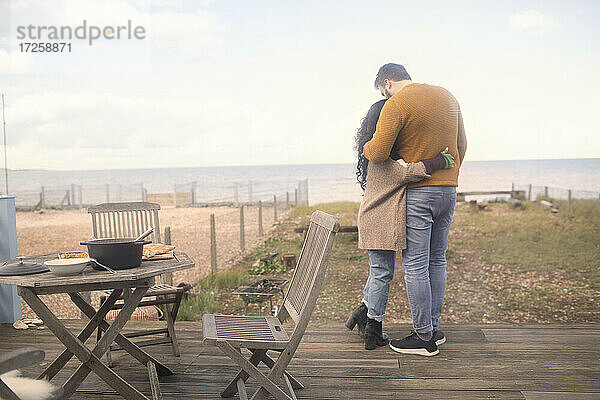 Affectionate Paar umarmt auf Ozean Strand Terrasse