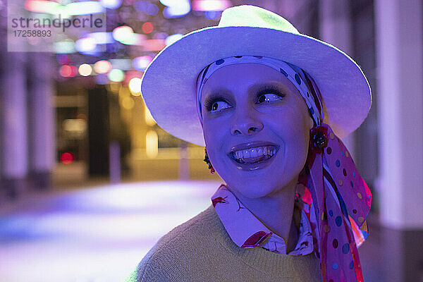 Porträt glücklich stilvolle Frau in Kopftuch und Fedora unter Neonlicht