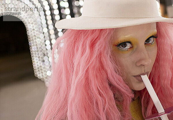 Close up Porträt stilvolle Frau mit rosa Haaren trinken aus Stroh