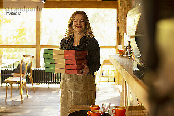 Porträt glücklich weiblichen Pizzeria Besitzer hält Pizza-Boxen