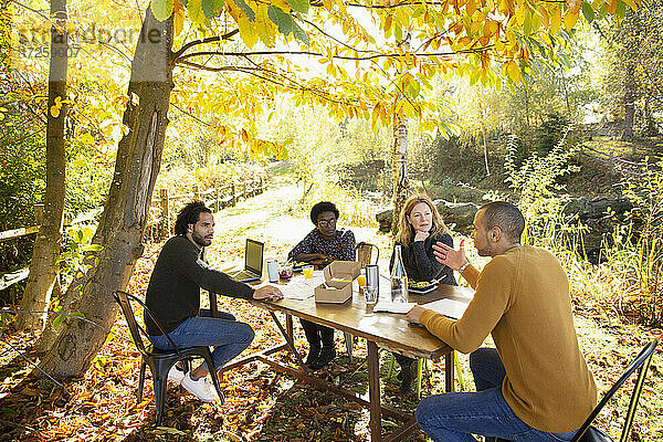 Geschäftsleute Essen und Treffen am Tisch in sonnigen Herbst Park